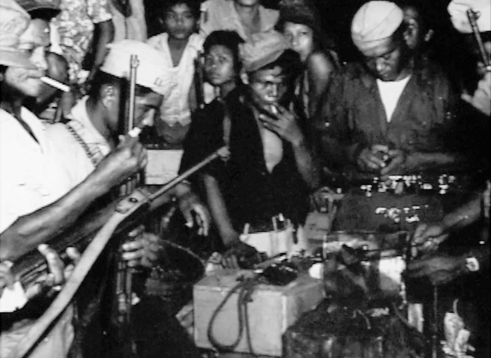 Photo of Filipino guerrillas clustered around a radio